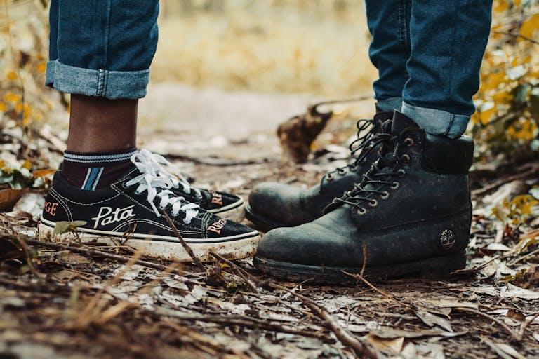 Close-up of diverse footwear on a wooded path symbolizing unity and adventure.